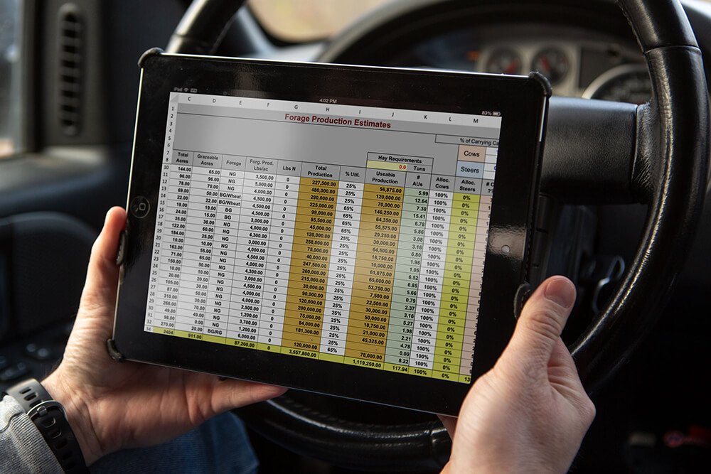 Producer looks at spreadsheets on their tablet in their truck